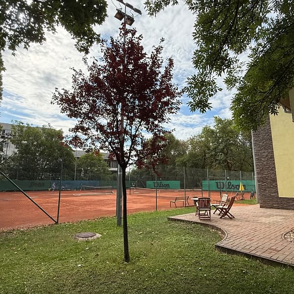 Trávnik s posedením pri budove klubu TennisOne